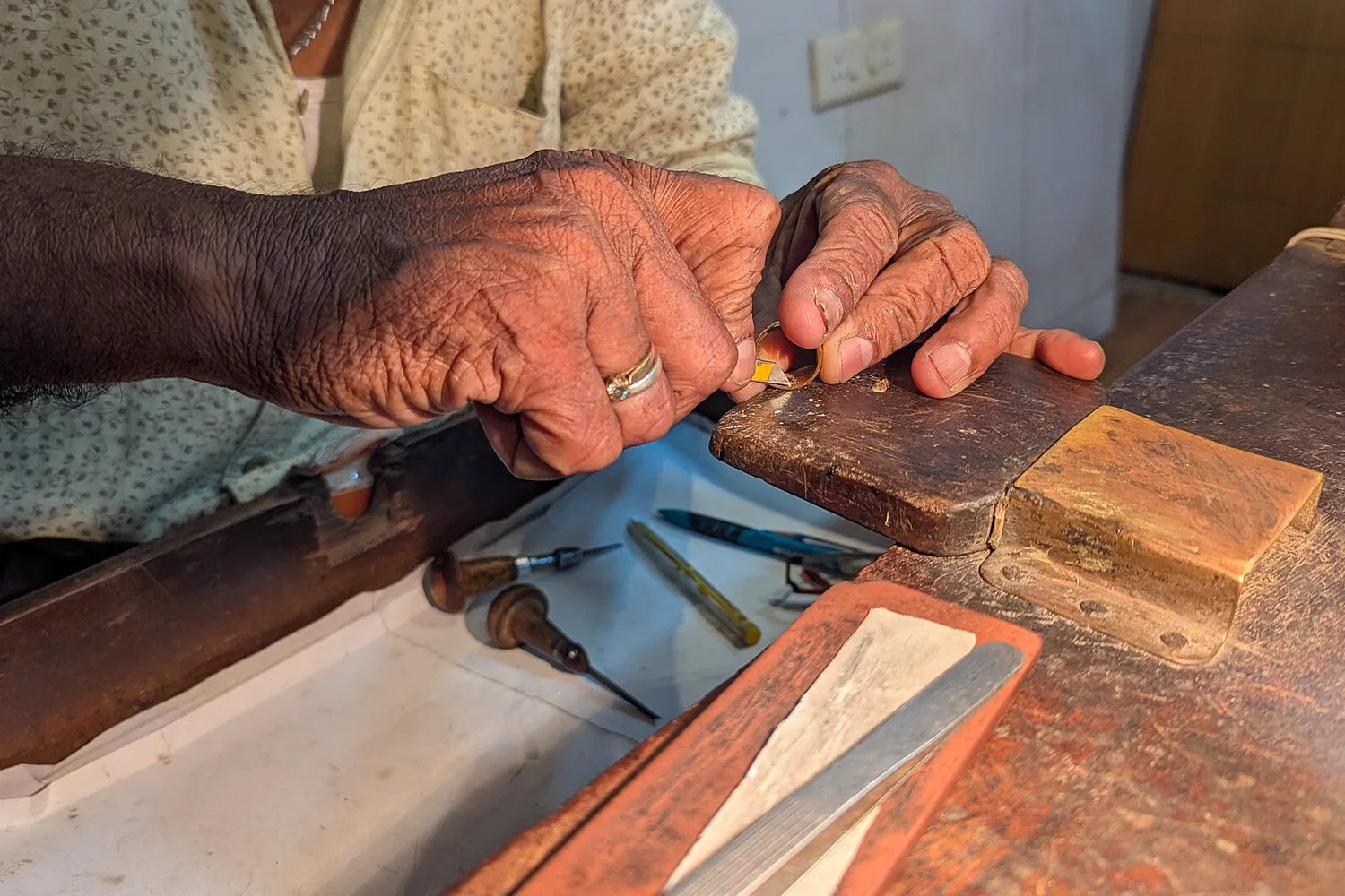 Orfèvre gravant une bague au burin dans son atelier